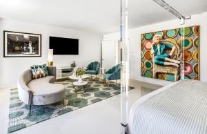 a bedroom with a king sized bed and a living room at Pink Paloma in Palm Springs