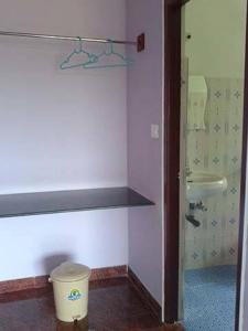 a bathroom with a toilet and a bucket in it at Chill Inn Guest House in Anjuna
