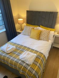 een slaapkamer met een groot bed met gele kussens bij Harbourside in Garlieston