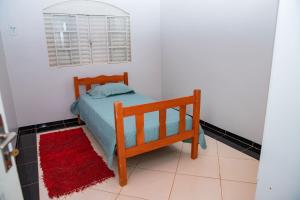 a small bedroom with a bed and a red rug at Casa com Wi-Fi e otima localizacao em Juina MT in Juína