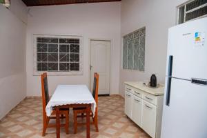 a kitchen with a table and chairs and a refrigerator at Casa com Wi-Fi e otima localizacao em Juina MT in Juína