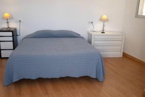 a bedroom with a bed with a blue blanket and two night stands at Apartamento con Vistas en Albaicin II in Granada