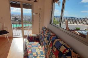 um sofá numa sala de estar com vista para uma piscina em Apartamento con Vistas en Albaicin II em Granada