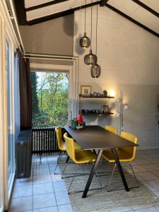 辛佩爾費爾德的住宿－Zuid Limburg Huisje Josefien，一间带桌子和黄色椅子的用餐室