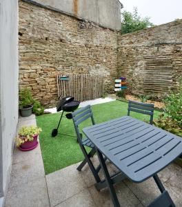 a blue picnic table and two chairs in a garden at L'abris côtier in Concarneau