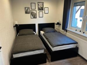 two beds sitting next to a window in a bedroom at Ferienwohnung am See in Borken