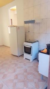 W kuchni znajduje się kuchenka i lodówka. w obiekcie Casa de Praia / Cabo Frio w mieście Tamoios
