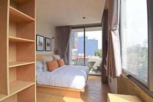 ein Schlafzimmer mit einem Bett und einem großen Fenster in der Unterkunft Boutique Hotel Durango219 in Mexiko-Stadt