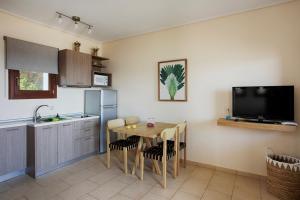 a kitchen with a table and a sink and a tv at Aithra -Agios Petros Andros in Gavrio
