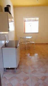 an empty room with a table and a refrigerator at Casa de Praia / Cabo Frio in Tamoios