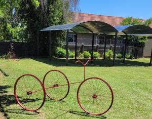 two red bikes on the grass in a park at Delux Guesthouse in Volksrust