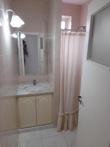 y baño con lavabo y ducha con espejo. en Apartamento Esmeralda en Mar del Plata