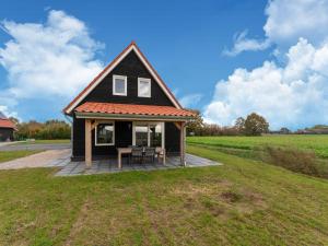 a small black house with a picnic table in a field at Beautiful Holiday Home in Scherpenisse with Terrace Garden in Scherpenisse
