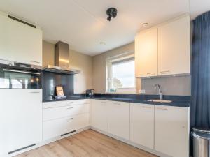 a kitchen with white cabinets and a window at Beautiful Holiday Home in Scherpenisse with Terrace Garden in Scherpenisse