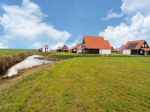 a row of houses in a field with a creek at Beautiful Holiday Home in Scherpenisse with Terrace Garden in Scherpenisse