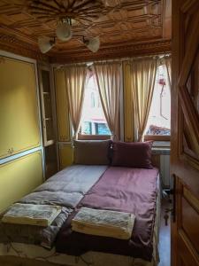 a small bed in a room with a window at Стаи за гости Бащино огнище in Koprivshtitsa