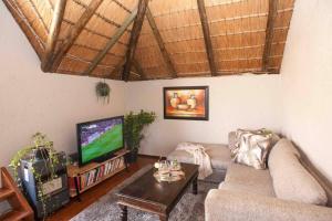 a living room with a couch and a flat screen tv at Perfectly located beauty in secure Estate in Sandton