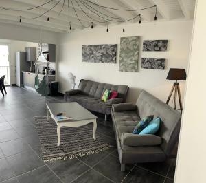 - un salon avec deux canapés et une table dans l'établissement Appartement spacieux au village du flamboyant, à Baie Nettlé