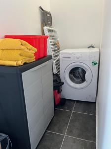 une buanderie avec un lave-linge et un lave-linge dans l'établissement Appartement spacieux au village du flamboyant, à Baie Nettlé