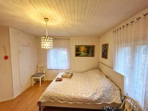 a bedroom with a bed and a chandelier at Finnish house near the forest in Lappeenranta