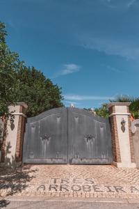 une grande porte métallique sur une route en briques dans l'établissement Monte 3 Alfarrobeiras, à São Brás de Alportel