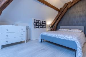 a bedroom with a blue bed and a dresser at L' appartement de la Paix in Romorantin
