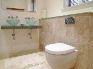 a bathroom with a toilet and two sinks at The Coach House in Syston