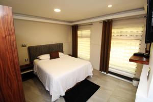 1 dormitorio con cama blanca y ventana en OSLO 5, en Ciudad de México