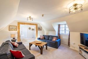 a living room with a couch and a tv at MacFarlane Apartment in Taynuilt