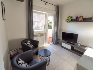 uma sala de estar com duas cadeiras e uma televisão em Casa Felicità em Udine