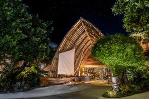 un gran edificio de bambú con una vela blanca en Le Taha'a by Pearl Resorts, en Motu Tautau