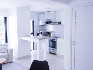 a kitchen with white cabinets and a white counter top at 5C Departamento de dos ambientes, por escalera. in Mar del Plata