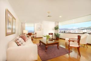 Hotel Rio Amazonas في كيتو: غرفة معيشة مع أريكة بيضاء وطاولة