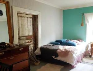 a bedroom with a bed with blue walls at Hirsihuvila, sauna ja kylpyamme, levollista olemista in Loppi