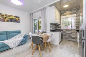 a living room with a table and a blue couch at Punta Prima Palm Beach Apartment in Punta Prima