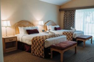 a hotel room with two beds and a window at Skaneateles Suites in Skaneateles