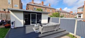a house with a deck with two chairs on it at Lovely unit elgin drive Coastal Bliss Your Seaside Retreat with City Excitement in Wallasey
