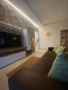 ein Wohnzimmer mit einem Sofa und einem Flachbild-TV in der Unterkunft Cà Sal Holiday Home in Lesina
