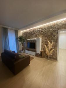 ein Wohnzimmer mit einem Sofa und einer Steinmauer in der Unterkunft Cà Sal Holiday Home in Lesina