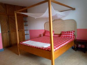 a bed in a room with a canopy bed at Auberge Cœur Océan in Joal-Fadiout