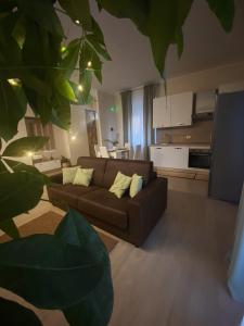 ein Wohnzimmer mit einem braunen Sofa und einer Küche in der Unterkunft Cà Sal Holiday Home in Lesina