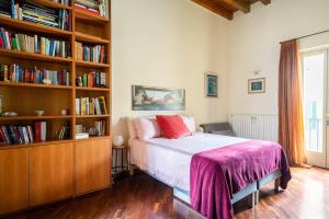 1 dormitorio con 1 cama y estantería con libros en Duomo Apartment CIR 017029-CNI-00186, en Brescia