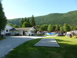 Un estacionamiento con un edificio y una carpa. en Birkelund camping, en Geilo