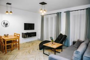 a living room with a couch and a table at Mazurski Apartament in Szczytno