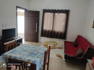 1 dormitorio con 1 cama, 1 silla y TV en Residencial Ramos, en Torres