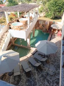 eine Aussicht über einen Pool mit Tischen und Sonnenschirmen in der Unterkunft Hotel Spa el Gran Coral By Rotamundos in Jocotepec