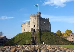 Un castillo en una colina con una bandera. en Stunning City Centre Apartments en Cardiff