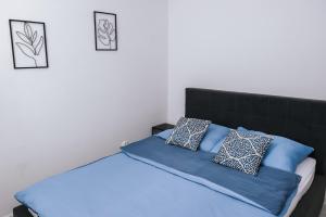 a bedroom with a bed with blue pillows on it at Mazurski Apartament 2 in Szczytno