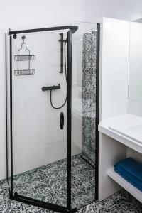 a shower with a glass door in a bathroom at Mazurski Apartament 2 in Szczytno