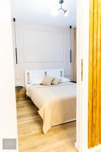 sypialnia z łóżkiem w białym pokoju w obiekcie Urban Nest w mieście Zalău